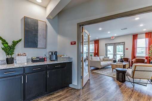 A modern kitchen with black cabinets and a wooden floor.