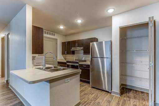 A modern kitchen with a stainless steel refrigerator and a sink with a faucet.
