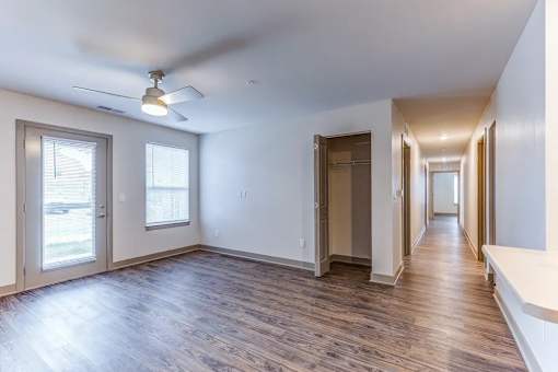 A spacious room with a ceiling fan and sliding glass doors.