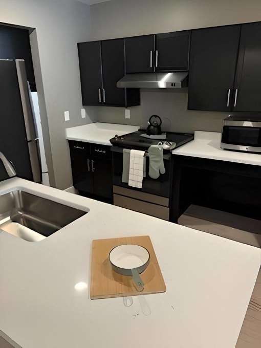 a kitchen with black cabinets and a white counter top at MountainView Flats, Glenwood Springs, CO