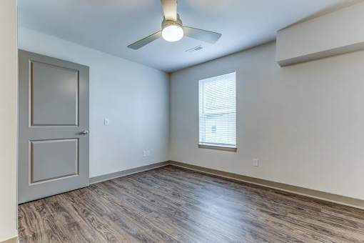 A room with a wooden floor and a ceiling fan.