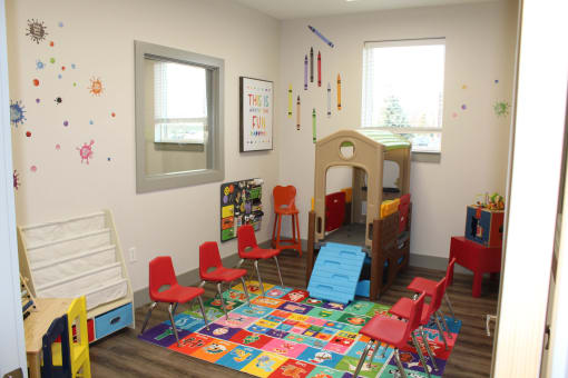 a childs play room with a bed and chairs and a rug  at Haven Homes Apartments, LP, Plainfield, Indiana