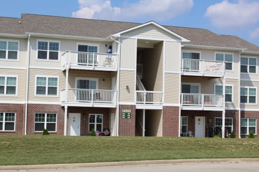 a building with two balconies and a lawn at Salem Place Apartments, Daleville, IN
