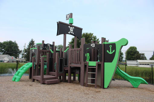 a playground with a mix of wooden structures and green and brown equipment at Salem Place Apartments, Daleville, 47334
