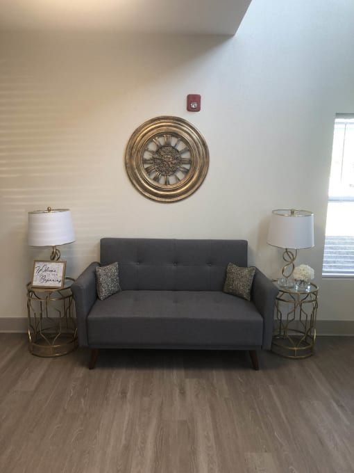 a living room with a couch and a clock on the wall  at Lake Park Market Apartments, Hobart, 46342