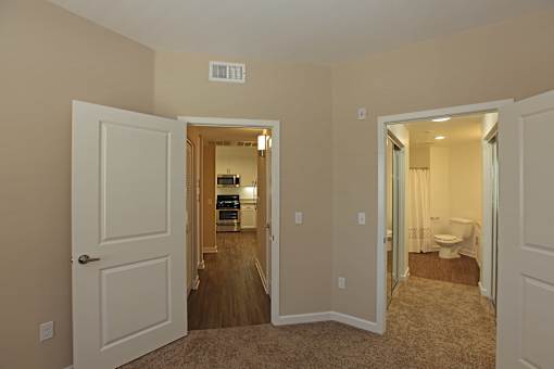 A room with a white door and a carpeted floor.