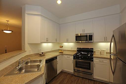 A kitchen with white cabinets and stainless steel appliances.