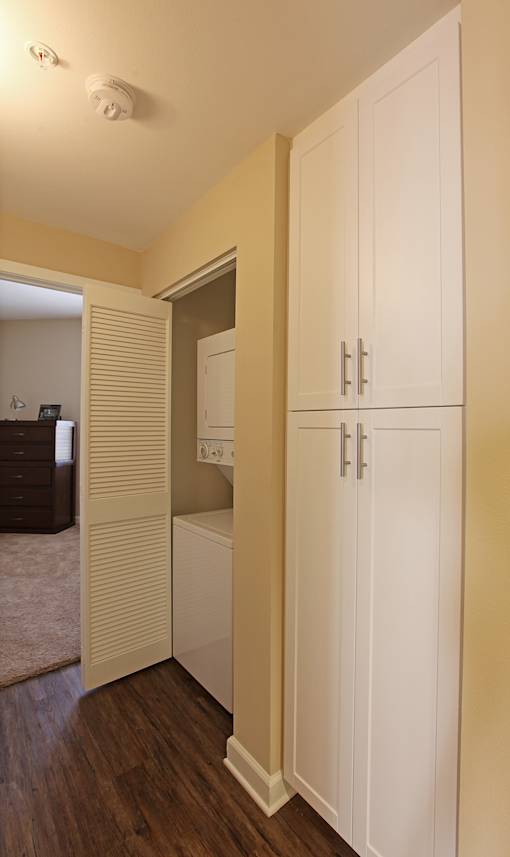 A white cabinet with a door is in the room.