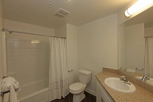 A white toilet sits next to a sink in a bathroom.