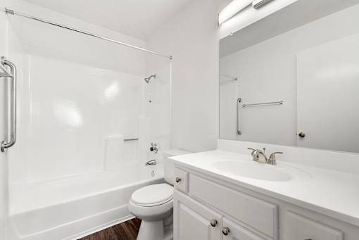 A white bathroom with a toilet, sink, and bathtub.