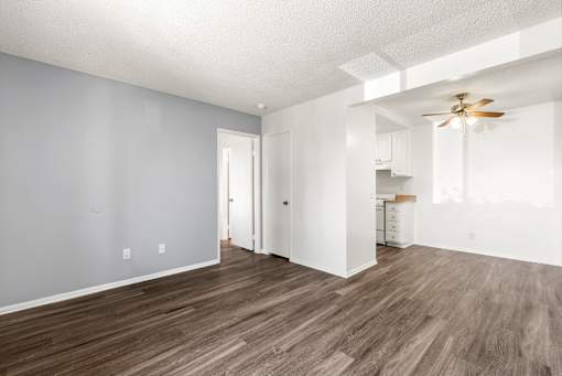 A room with a ceiling fan and wooden flooring.