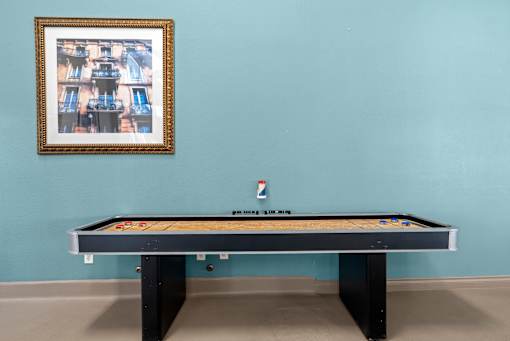 A pool table with a picture frame on the wall.