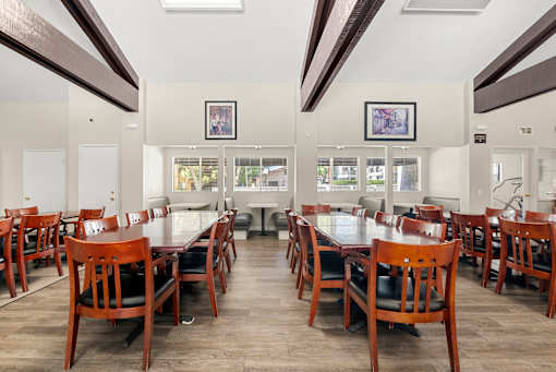 A dining room with a long table and chairs.