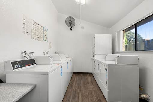 A clean, white-walled medical or laboratory room with a bench and a couple of cabinets.