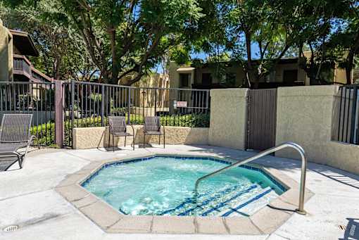 A small pool with a metal fence around it.