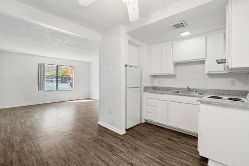 A kitchen with white cabinets and a refrigerator.