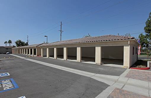 A parking lot with a building and a flag on the right side.