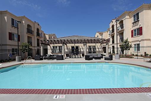 A swimming pool in front of apartment buildings.