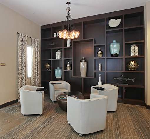 A living room with a brown carpet and a white chair.