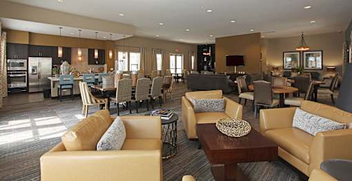 A spacious living room with a kitchen area in the background.