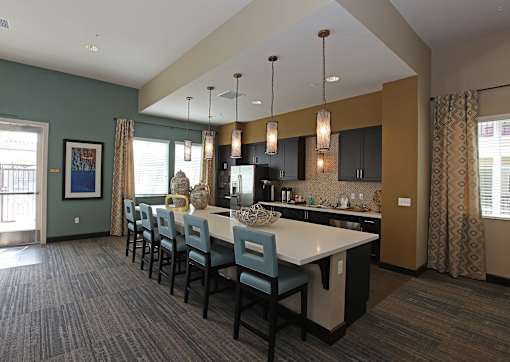 A kitchen with a long table and chairs.