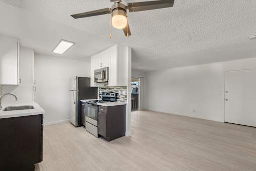 A modern kitchen with a stove, sink, and refrigerator.