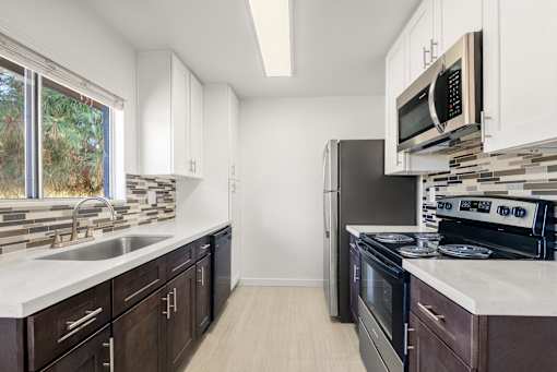 A kitchen with dark brown cabinets and stainless steel appliances.