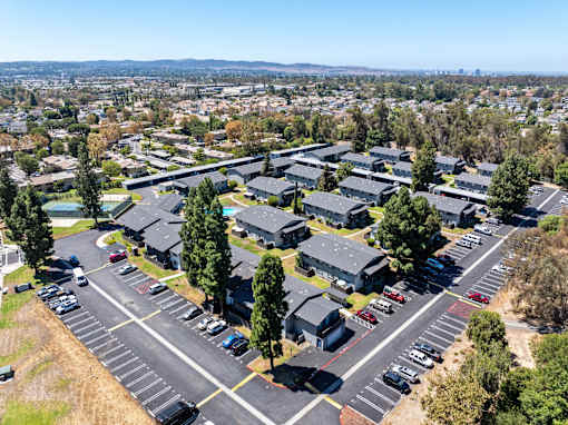 A parking lot with cars and a building in the background.