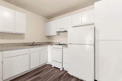A kitchen with white appliances and cabinets.