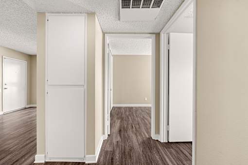 A white door is open in a room with wood flooring.