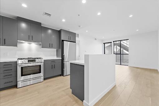 A modern kitchen with a white island in the middle.