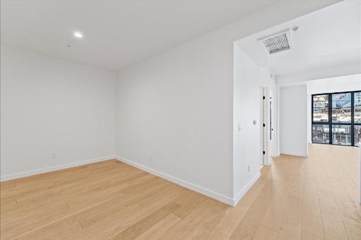 A room with wooden flooring and white walls.
