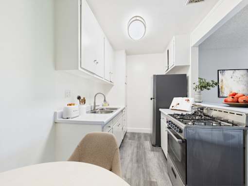 A modern kitchen with a stove, sink, and cabinets.
