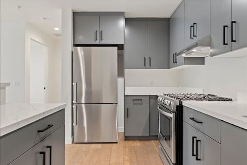 A modern kitchen with a stainless steel refrigerator and oven.