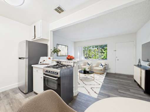 A modern kitchen with a dining area and a living room.