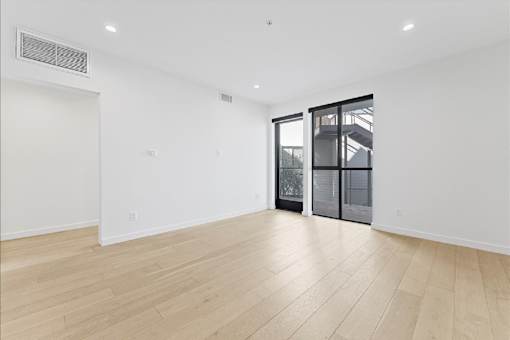 A room with a wooden floor and a sliding glass door.