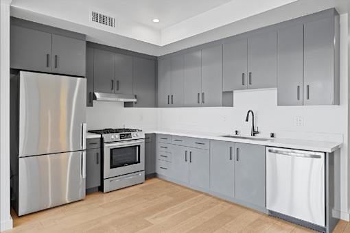 A modern kitchen with a stainless steel refrigerator and a dishwasher.