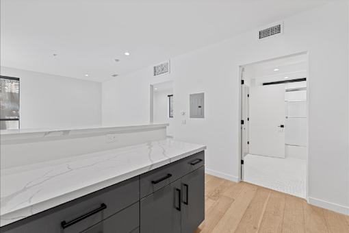 A kitchen with black cabinets and a white counter top.