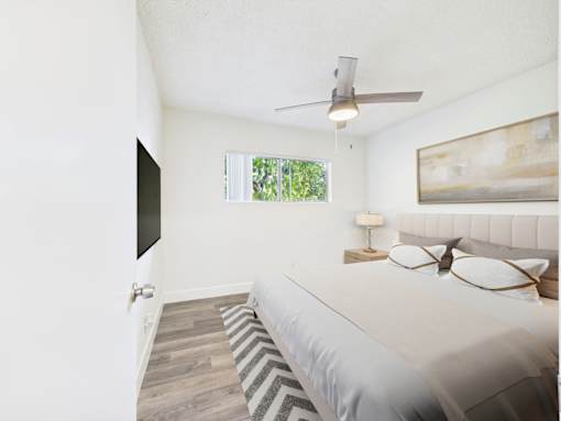 A bedroom with a bed, a ceiling fan, and a window.