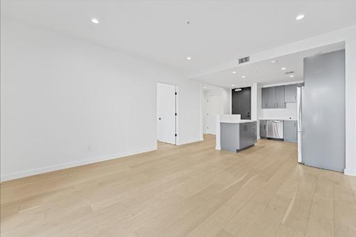 A kitchen area with a refrigerator, cabinets, and a countertop.