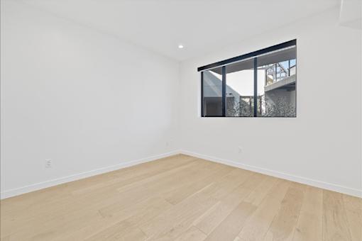 A room with a window and wooden flooring.