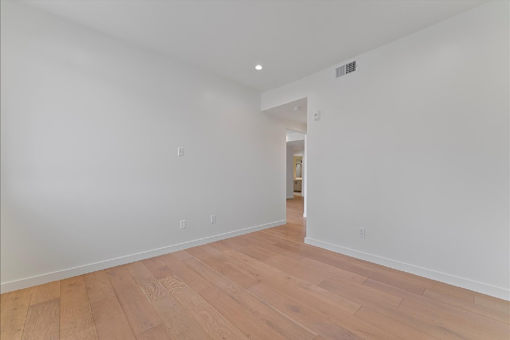 A room with wooden flooring and white walls.