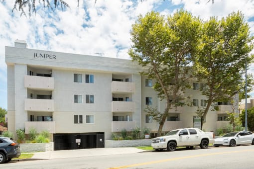 a white apartment building with cars parked in front of it