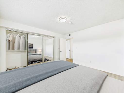A bedroom with a large bed and a wardrobe.