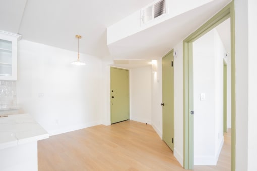 an empty living room with a hard wood floor and white walls
