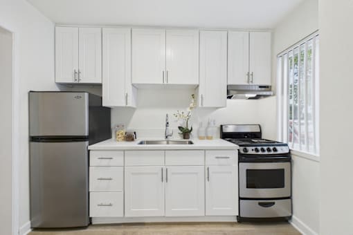 A kitchen with white cabinets and appliances.