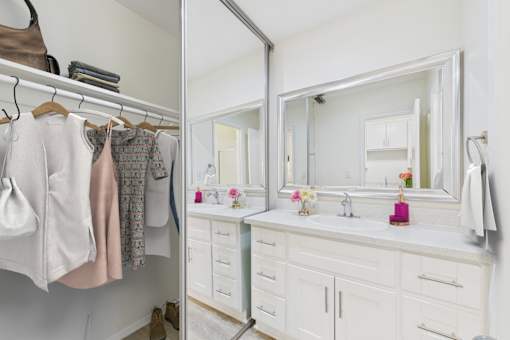 A bathroom with a white vanity and a mirror above it.