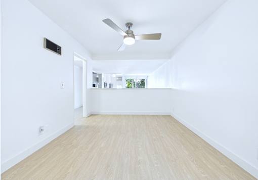 A room with a ceiling fan and light switch.