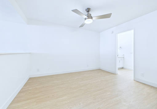 A room with a ceiling fan and light fixture.