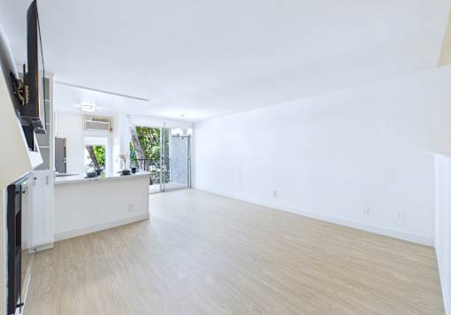A spacious living room with a television on the left side.